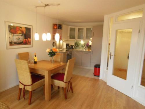 cocina y comedor con mesa de madera y sillas en Ferienwohnung mit Balkon in Hohegeiß, en Braunlage