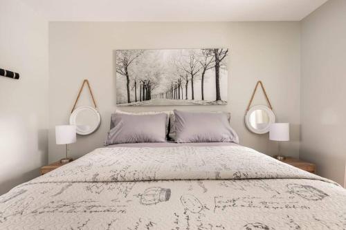 sypialnia z łóżkiem z dwoma lustrami na ścianie w obiekcie Un Havre de Bonheur w mieście Saint Adolphe D'Howard