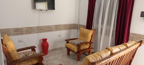 Departamentos por dia EL TREBOL في باسو دي لوس ليبريس: غرفة معيشة مع كرسيين وأريكة