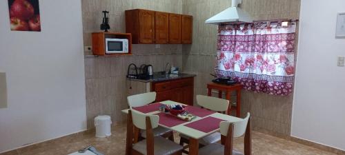 Departamentos por dia EL TREBOL في باسو دي لوس ليبريس: مطبخ مع طاولة وكراسي وميكروويف