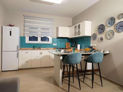 una cucina con armadi bianchi e piastrelle blu di Pasithea Luxury house a Archangelos