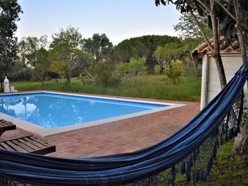 a hammock by a swimming pool in a yard at Monte Rosa Rural Guesthouse in Lagos