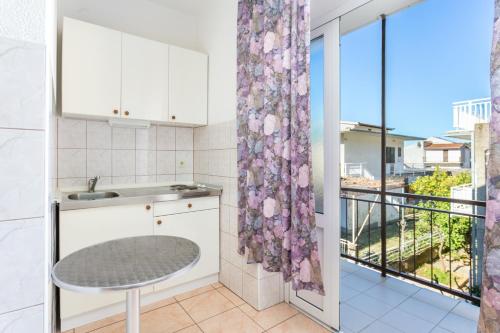 a kitchen with a table and a balcony at Apartments by the sea Podaca, Makarska - 2783 in Podaca