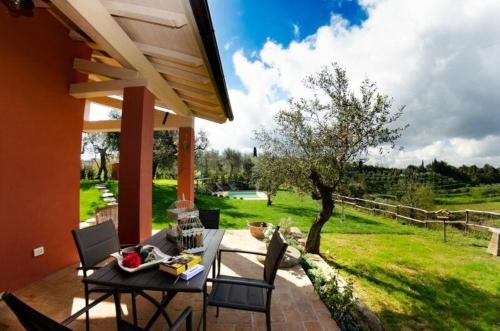 un patio con mesa, sillas y un campo en Ferienhaus mit Privatpool für 4 Personen ca 55 qm in Aiale, Toskana Provinz Pisa, en Lari