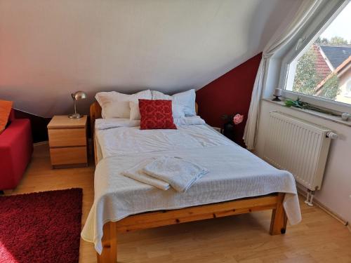 a small bedroom with a bed with red pillows at Ferienhaus für 6 Personen ca 120 m in Zepernick, Brandenburg Berlin und Umgebung in Panketal