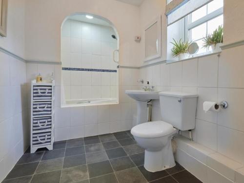 a bathroom with a toilet and a sink and a mirror at 2 Bed in Little Clifton SZ323 in Camerton