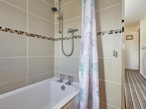a bathroom with a tub and a shower curtain at 3 Bed in Wasdale SZ205 in Santon Bridge