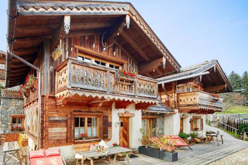 een houten huis met een balkon en een tafel bij Ferienhaus für sechs Erwachsene und drei Kinder mit Sauna und Kamin in Flachau