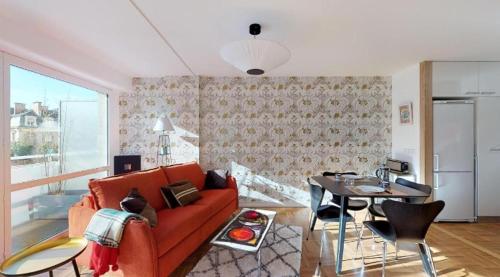 un salon avec un canapé rouge et une table dans l'établissement Le Delicious avec Terrasse - Hyper Centre, à Rennes