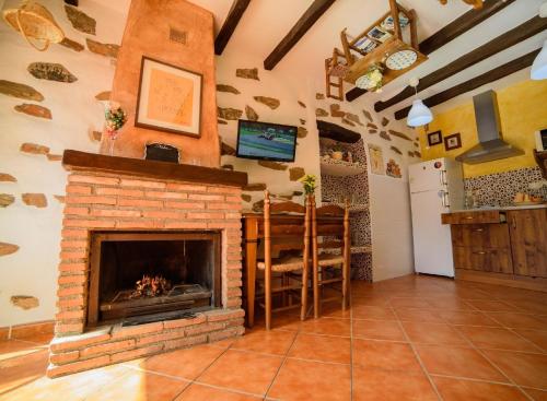 uma sala de estar com lareira de tijolos numa casa em Ferienhaus in Laroya mit Whirlpool, gemeinschaftlichem Pool und Grill em Laroya