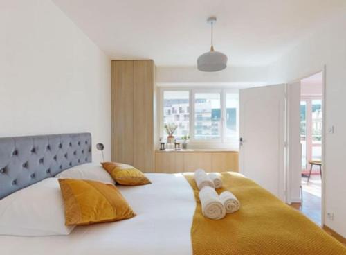 une chambre avec un grand lit blanc avec deux serviettes dans l'établissement Le Delicious avec Terrasse - Hyper Centre, à Rennes