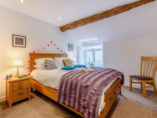 1 dormitorio con 1 cama con cabecero de madera y silla en 2 Bed in Tideswell 81534, en Tideswell