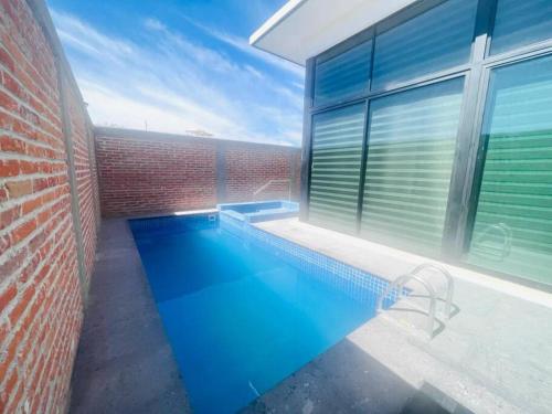 a swimming pool in front of a brick building at Renta en San Miguel De Allende in San Miguel de Allende