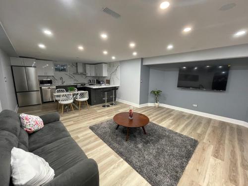 een woonkamer met een bank en een tafel bij 2BR basement Apt with Modern Comforts in Vaughan