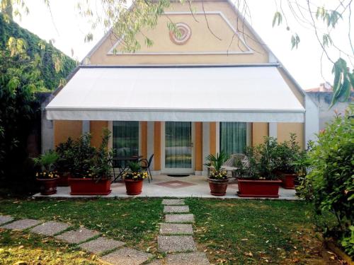 a building with a white awning and potted plants at Romantisches Gästezimmer 22 qm für max zwei Personen in Mira