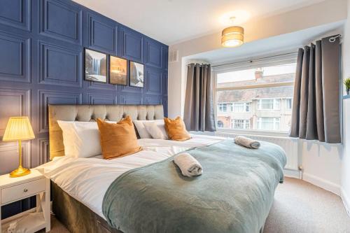 um quarto com uma cama grande e paredes azuis em Stunning Serviced Accommodation Near City Centre em Allesley