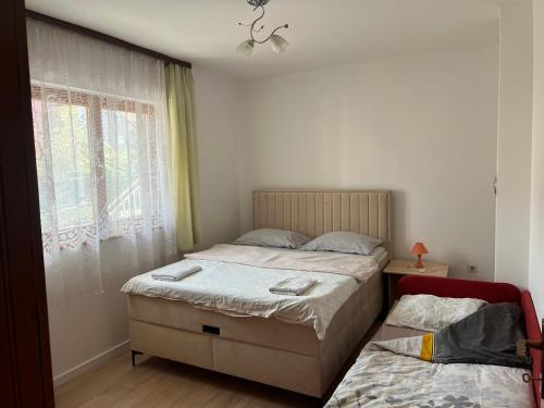 two twin beds in a bedroom with a window at Cheap house near the center of the city in Mostar