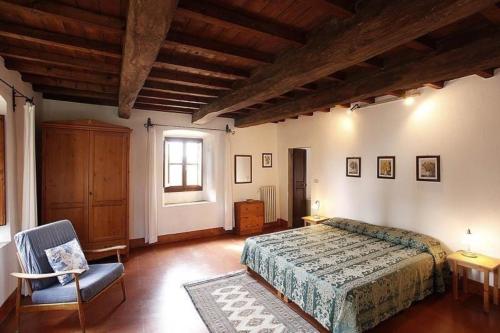 1 dormitorio con 1 cama, 1 silla y 1 ventana en Casa Corzanello, en San Casciano in Val di Pesa