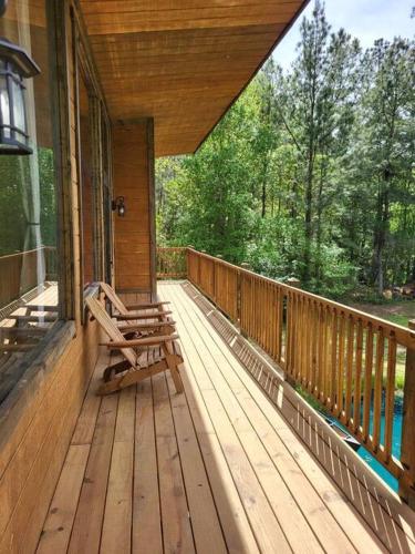 a porch of a house with two benches on it at Waterfront Houston Hide out In A Magical Forest in Waller