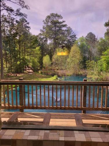 a wooden deck with a view of a river at Waterfront Houston Hide out In A Magical Forest in Waller