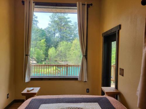 a bedroom with a bed and a large window at Waterfront Houston Hide out In A Magical Forest in Waller