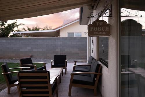 a porch with chairs and a sign on a building at Desert RanchHouse in Page