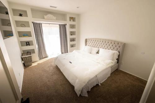 a bedroom with a large white bed with a window at Desert RanchHouse in Page