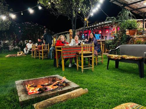 a group of people sitting around a fire pit at Alpamayo Casa Hotel - Restaurante in Yungay