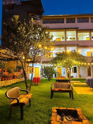 a yard with benches and trees in front of a building at Alpamayo Casa Hotel - Restaurante in Yungay
