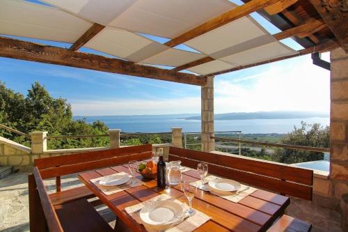 einen Holztisch auf einer Terrasse mit Meerblick in der Unterkunft Ferienhaus mit Privatpool für 6 Personen ca 120 m in Baska Voda, Dalmatien Mitteldalmatien in Baška Voda