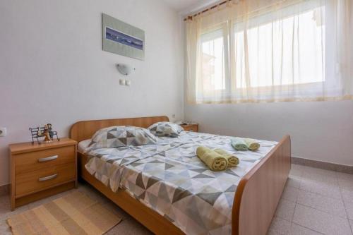een slaapkamer met een bed met handdoeken erop bij Apartments with a parking space Lopar, Rab - 18388 in Lopar
