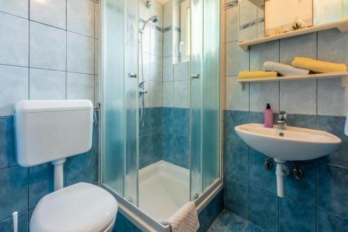 een badkamer met een douche, een toilet en een wastafel bij Apartments with a parking space Lopar, Rab - 18388 in Lopar