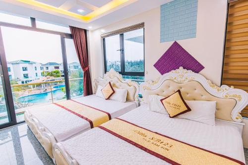 two beds in a room with a balcony at VILLA SB123 FLC SẦM SƠN in Sầm Sơn