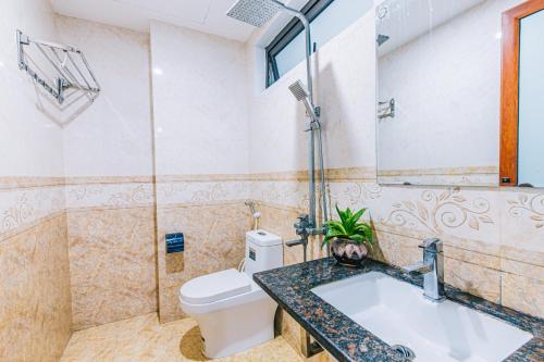 a bathroom with a tub and a toilet and a sink at VILLA SB123 FLC SẦM SƠN in Sầm Sơn