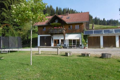 a house with a balcony in front of it at Ferienwohnung auf dem Bauernhof- ideal für Familien mit Kindern in Sulzberg