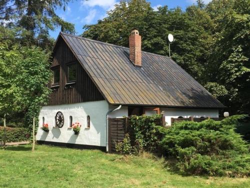 a white and black house with flowers in a yard at Ferienhaus Knorburg im Herzen Nordfrieslands in Enge-Sande