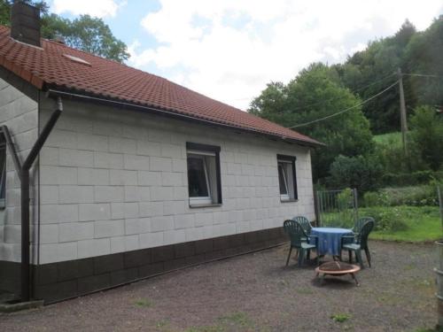 una casa con una mesa y sillas frente a ella en Ferienhaus in ruhiger Lage in der Nähe zahlreicher Wanderrouten, Reitmöglichkeit, en Wutha-Farnroda