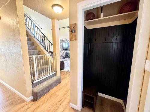 a hallway with a black wall and stairs in a house at Cozy Cabin in the City plus GYM in Winnemucca
