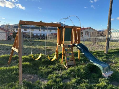 a playground with a slide in the grass at Cozy Cabin in the City plus GYM in Winnemucca