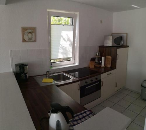 eine kleine Küche mit einem Waschbecken und einem Fenster in der Unterkunft Ferienhaus für 4 Personen ca 70 m in Bergen auf Rügen, Ostseeküste Deutschland Rügen in Bergen auf Rügen