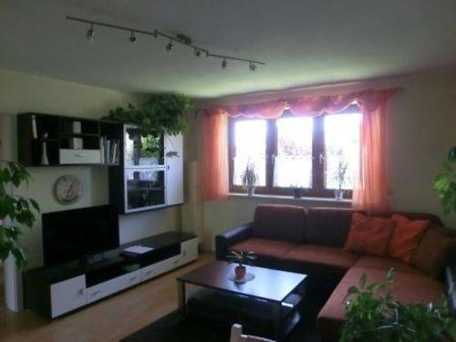a living room with a couch and a table at Ferienwohnung in Grafing Bei München mit Großem Garten in Grafing