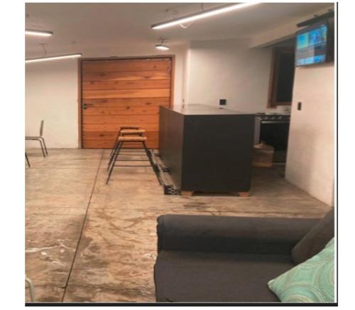 a living room with a counter and a wooden door at Loft Volcanes Amecameca in Amecameca de Juárez