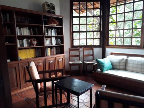 un soggiorno con divano e tavolo di Versall Homestead a Petrópolis
