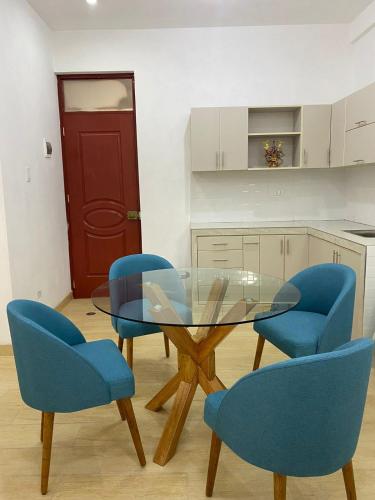 ein Esszimmer mit blauen Stühlen und einem Glastisch in der Unterkunft Mini apartamento en Ayacucho in Ayacucho