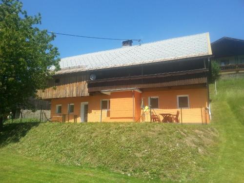 a house on a hill next to a field at Modernes Ferienhaus in bergiger Lage nahe Kärntner Seelandschaft 