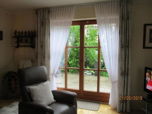 a living room with a chair and a sliding glass door at Wohnung in Pidingerau mit Großer Terrasse in Piding