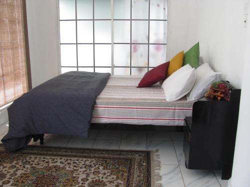 a bedroom with a bed with pillows and a window at White House in Wattala