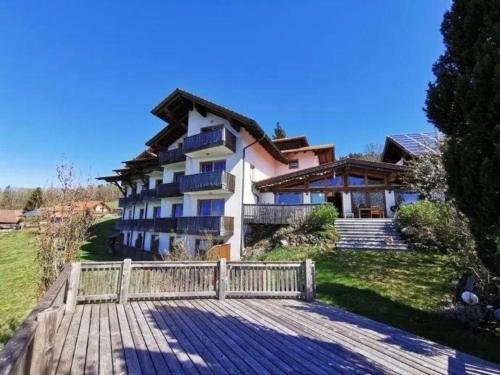 a building with a wooden walkway in front of it at Studio für 3 Personen ca 30 qm in Sankt Englmar, Bayern Bayerischer Wald in Hilm