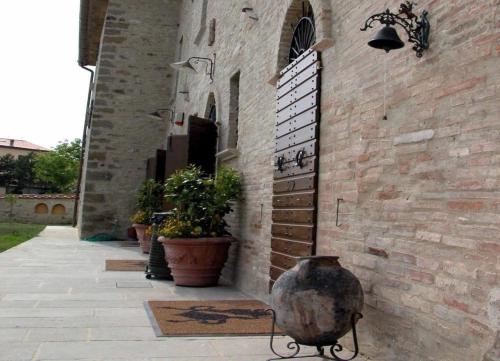 um edifício de tijolos com um vaso na lateral em Ferienhaus in Piosina mit Garten, Whirlpool und Grill em Città di Castello