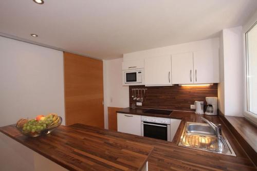 a kitchen with a sink and a bowl of fruit on a counter at Appartement in Kappl mit Eigenem Balkon in Kappl